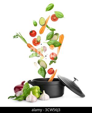 Cooking pot and different flying vegetables on white background Stock Photo