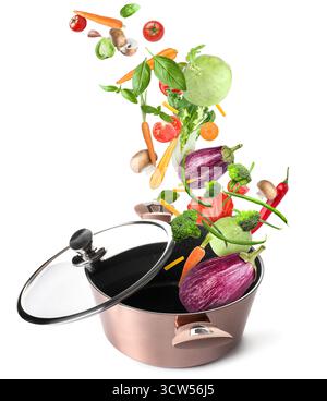 Cooking pot and different flying vegetables on white background Stock Photo