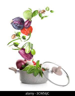 Cooking pot and different flying vegetables on white background Stock Photo