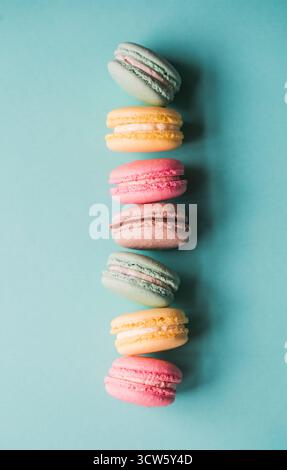 Top view close up of colorful macarons on blue background. Stock Photo