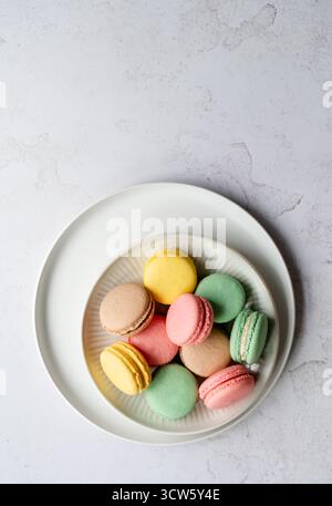 Top view of plate of assorted colorful macarons on white background. Stock Photo