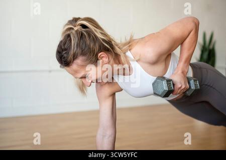 Woman working out in studio with dumbbell Stock Photo