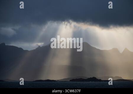 Light rays shine over mountain peaks, Lofoten Islands, Norway Stock Photo