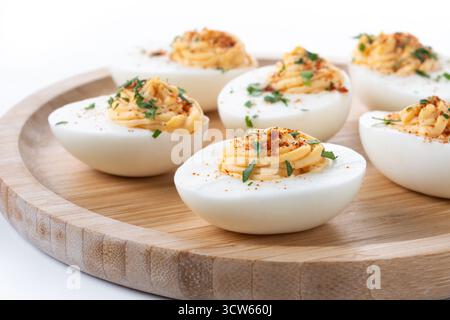 Homemade hard Boiled Deviled Eggs garnished with herbs isolated on white background. Stock Photo