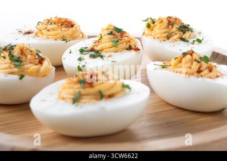 Homemade hard Boiled Deviled Eggs garnished with herbs isolated on white background. Stock Photo