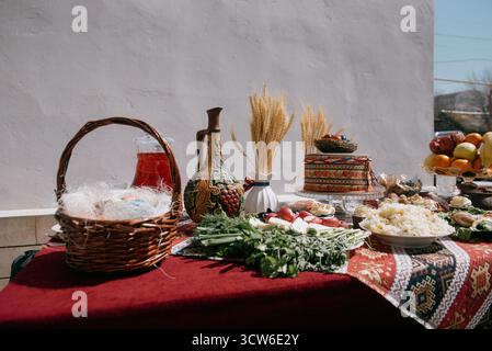 A large plate of pilaf with rice and raisins on a festive table. White rice with saffron and raisins in a plate against a bright red patterned tablecl Stock Photo