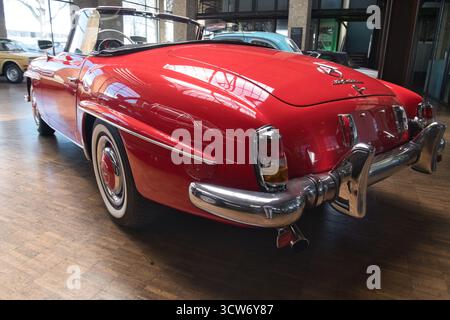 Red Classic German Roadster Rear View - Low-angle rear view of a classic red Mercedes-Benz convertible showcasing its chrome bumper, taillights, and e Stock Photo