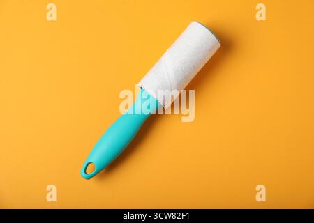 One lint roller on orange background, top view Stock Photo
