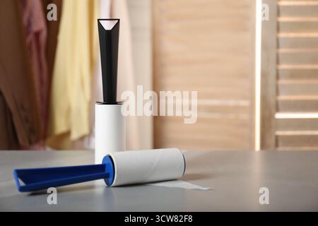 Lint rollers on grey table indoors, closeup. Space for text Stock Photo