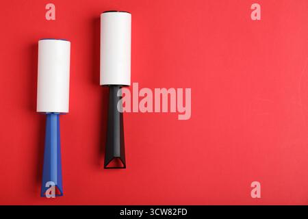Two lint rollers on red background, flat lay. Space for text Stock Photo
