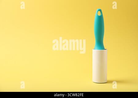 One lint roller on yellow background, space for text Stock Photo