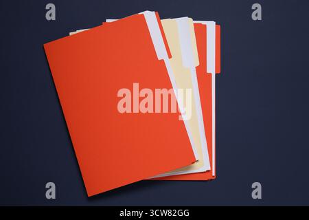 Many documents in folders on dark blue background, top view Stock Photo