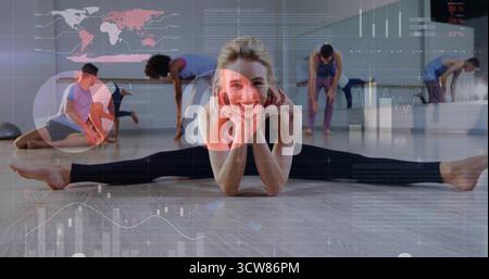 Smiling instructor in leggings performing side split in studio with wood floor, mirror AR overlays. Fitness, flexibility, training, wellness, studio, Stock Photo
