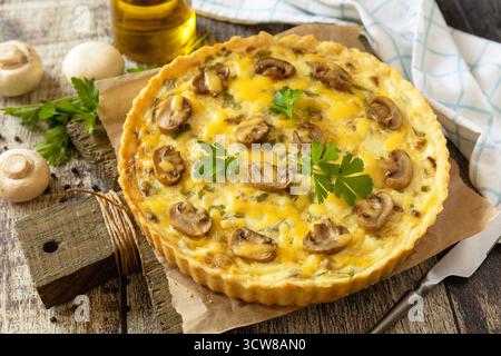 Delicious homemade mushroom quiche with mushrooms and green beans on rustic table. Stock Photo