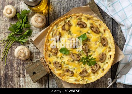 Delicious homemade mushroom quiche with mushrooms and green beans on rustic table. Top view flat lay background. Stock Photo