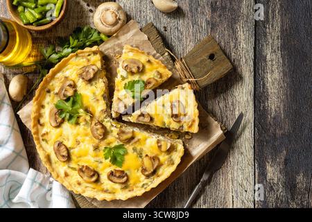 Delicious homemade mushroom quiche with mushrooms and green beans on rustic table. Top view flat lay background. Copy space. Stock Photo