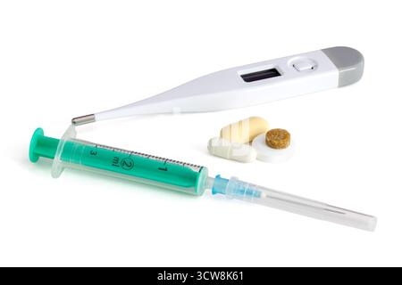Assortment of medical items including pills, digital thermometer, adhesive bandage, bandage roll and dropper on a white background. Stock Photo
