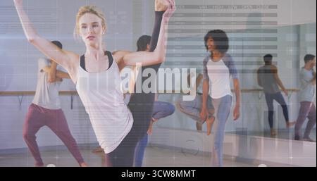 Instructor leading group by performing leg-and-arm stretch in studio, with wooden barre and mirror. Fitness, exercise, movement, wellness, discipline, Stock Photo