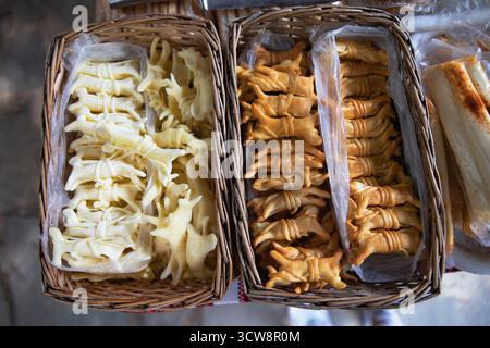 Smoked and fresh braided cheese displayed in wicker baskets on the local market in Yaremche, Ukraine. Traditional Carpathian dairy product made from c Stock Photo