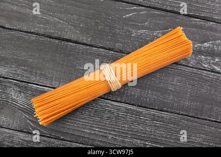 brown integrale spaghetti on black wood background top view Stock Photo