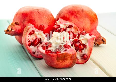 sliced pomegranate on blue wood background on white Stock Photo