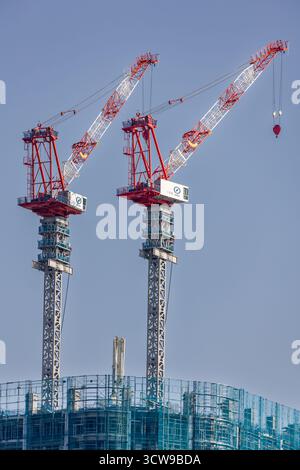 Construction site of a modern skyscraper with large cranes in a major city. Stock Photo