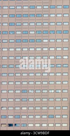 Symmetrical pattern of repeating windows on the facade of a modern office building. Stock Photo