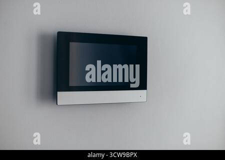 A video intercom screen on a white apartment wall Stock Photo