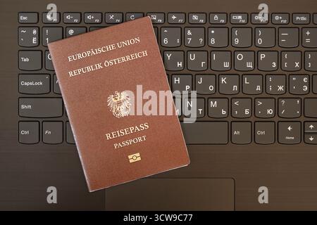 Austria passport lies on black laptop keyboard buttons background close up. Technologies and control in Europe concept Stock Photo