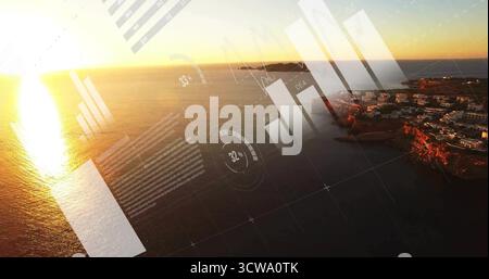 Displaying HUD overlay over aerial coastal sunset scene, with bar graphs, line charts Stock Photo