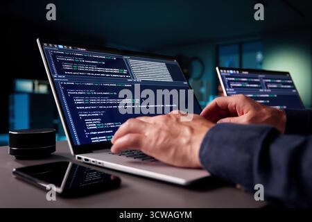 Elderly Programmer Codes In Office Late At Night On Laptops. Stock Photo
