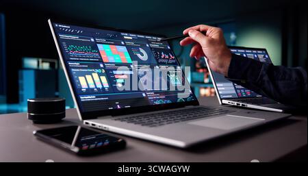 Senior Business Analyst Working Late On Predictive Data Management Dashboard Stock Photo