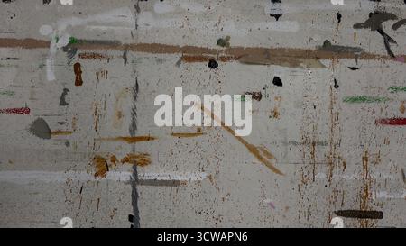 Urban textured surface street or wall heavily layered with dirty, abstract paint splatters and streaks. Gray background with muticolored lines Stock Photo