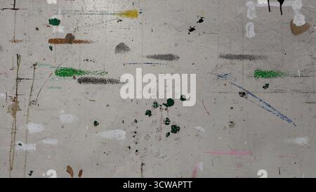 Urban textured surface street or wall heavily layered with dirty, abstract paint splatters and streaks. Gray background with muticolored lines Stock Photo