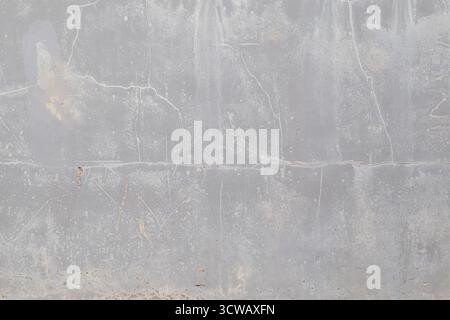 Front view of a cracked, weathered and dirty light gray stone or concrete wall. Abstract high resolution full frame textured background, copy space. Stock Photo