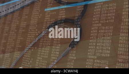 Displaying silver stethoscope resting on wooden desk workspace, featuring computer code overlay Stock Photo
