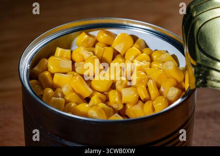 Canned pickled corn, close up. The open can with sweet corn Stock Photo