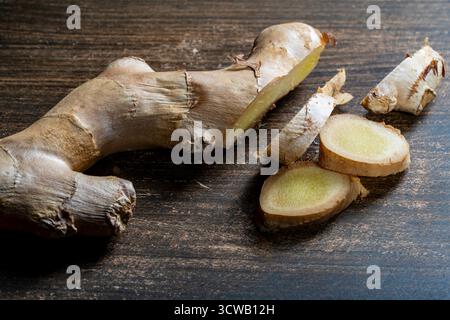 Cutting ginger root into pieces on a wooden cutting board, close up Stock Photo