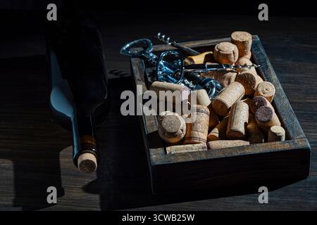 Wine corks, corkscrew and bottle on wooden table, close up Stock Photo