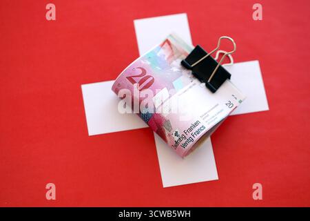 Swiss franc banknotes and flag. The current francs money bills lies on flag in big amount. The concept of business in Switzerland Stock Photo