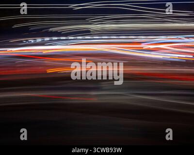 Abstract light trails creating speed and motion on a dark background, representing energy, urban life, and technology with a dynamic blend of white, r Stock Photo