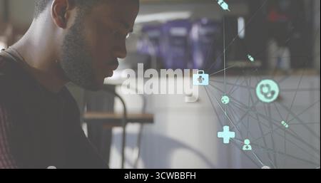 Leaning man wearing t-shirt analyzing medical icons at cafe with purple coffee machines, copy space Stock Photo