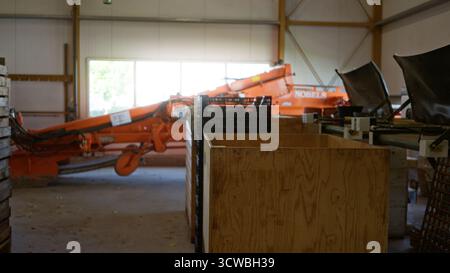 Blurred interior of factory with defocused machinery and wooden crates, highlighting industrial equipment in an out of focus setting with natural ligh Stock Photo