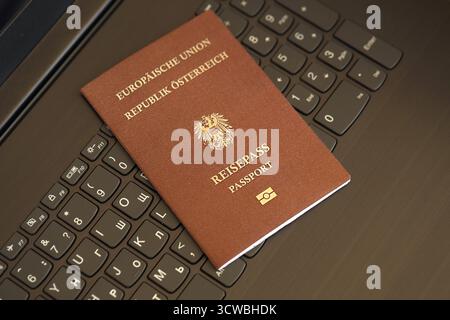 Austria passport lies on black laptop keyboard buttons background close up. Technologies and control in Europe concept Stock Photo