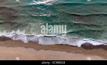 aerial view of waves breaking on the sandy shore Stock Photo