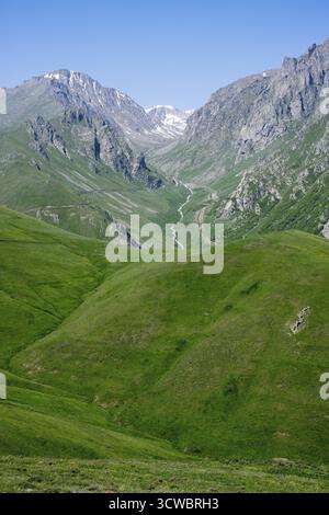 Hills and mountains with a snow-covered valley under a blue sky, at the highest pass in Armenia, Meghri Pass, Tashtun Pass, Syunik Province, Syunik, A Stock Photo