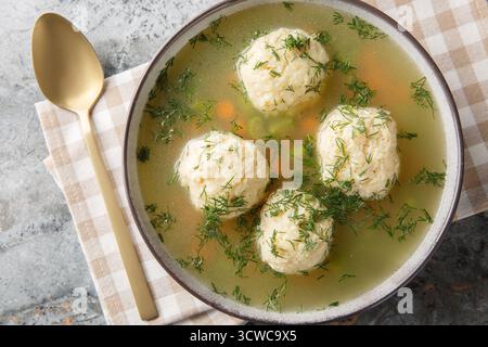 Matzah Ball Soup for Passover closeup on the plate on the table. Horizontal top view from above Stock Photo
