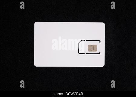 White SIM card isolated on black background. Plastic SIM card for mobile phone, close up Stock Photo