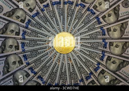 Bitcoin BTC virtual money and US dollar banknotes. Background with bitcoin cryptocurrency coins and US dollar. Gold bitcoin with a portrait of Benjami Stock Photo