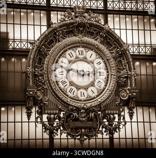 Golden clock of the museum D'Orsay. Musee d'Orsay has the largest collection of impressionist and post-impressionist paintings in the world. Sepia Stock Photo
